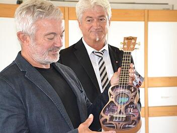 Regionalleiter Fritz Glock (rechts) überreichte dem begeisterten Musiker Thomas Zapf unter anderem eine Minigitarre. Foto: Uschi Prawitz
