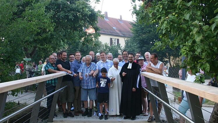 Untern den Augen zahlreicher G&auml;ste und Stadtr&auml;te wurde der Brauch gepflegt, mit dem Durchschneiden des Bandes die neue Wallgrabenbr&uuml;cke offiziell freizugeben. Hand respektive Schere legten an: Bauhofleiter Jan M&uuml;ller, B&uuml;rgermeister Tobias Ehrlicher, Gerd Helbig (Schwei&szlig;- und Holzarbeiten), Timo Machold (Konstruktion), Gemeindereferentin Birgit M&uuml;ller und Pfarrer Christian Rosenzwei (von links). Foto: Martin Rebhan
