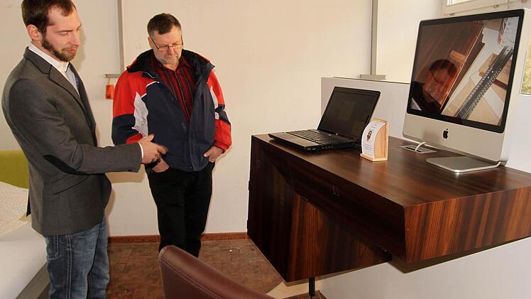 Ricardo Finn erläutert seinen Multimediasekretär aus geräucherter Lärche. Foto: Günther Geiling