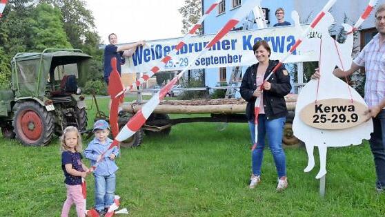 Die Akteure der KWG legen letzte Hand an bei der Aufstellung des Einladungsbanners mit den Tanzfiguren und Bändern. Von links, Bernd Redwitz (Vorsitzender der KWG), David Gödel (Kerwa-Bürgermeister), Carolin Zipfel-Kempf (Vertrauensfrau der evangelisch-lutherischen Kirchengemeinde), Michael Bohl (Zweiter Bürgermeister) und die jüngsten Kerwafreunde, Pauline und Simon (vorne).  Foto: Karl-Heinz Hofmann