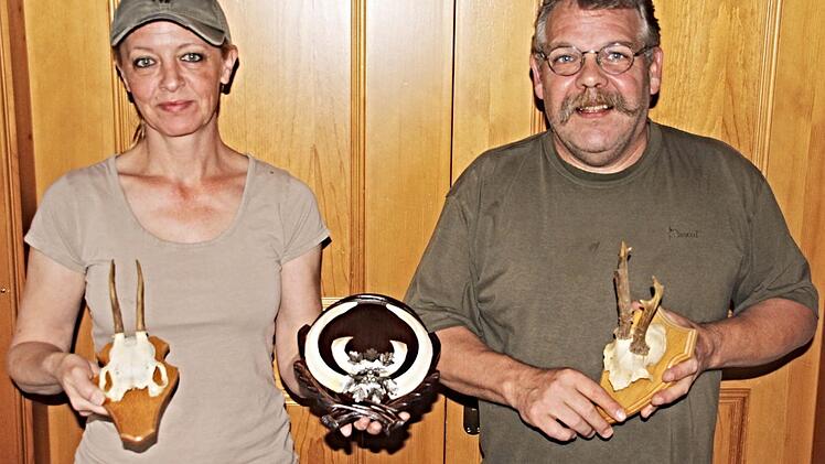 Monika zeigt das Gehörn ihres ersten Bocks und die imposanten Hauer eines Keilers, den sie erlegt hat. Ihr Mann Thomas hält das Gehörn seines ersten Rehbocks in Händen. Foto: Helmut Will