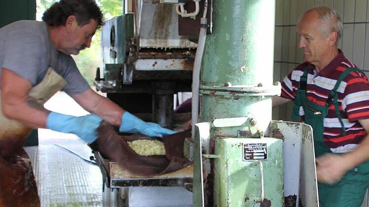 Hans-Jürgen Herzig (links)  und Heinz Spindler quetschen die Äpfel aus heimischen Gärten aus. Foto: Ralf Kestel