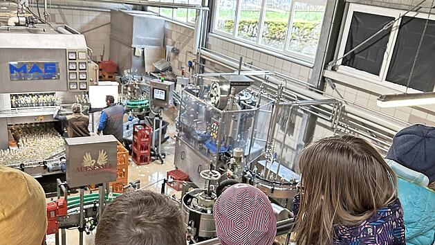 Besonders spannend fanden die Kinder, dass zwischen den Anlagen Arbeiter beispielsweise Flaschen verschlie&szlig;en, die von der Maschine ausgesto&szlig;en werden.