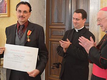Der Apostolische Nuntius Erzbischof Peter Zurbriggen (rechts) und Monsignore Steven Lopes (Mitte) applaudieren für den neuen Träger des Gregorius-Ordens, Hans-Jürgen Feulner. Foto: Daniel Podertschnig