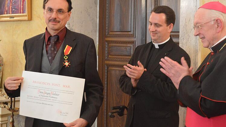 Der Apostolische Nuntius Erzbischof Peter Zurbriggen (rechts) und Monsignore Steven Lopes (Mitte) applaudieren für den neuen Träger des Gregorius-Ordens, Hans-Jürgen Feulner. Foto: Daniel Podertschnig