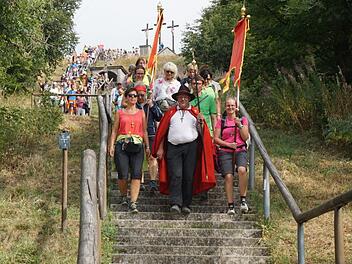 Diel letzten Meter: Ein beeindruckendes Bild, wenn die Würzburger Wallfahrer vom Gipfel des Kreuzbergs über die Treppe nach unten ziehen. Angeführt werden sie von Pilgerführer Klaus Rind, der in diesem Jahr von Claudia Lurz (links) und Thomas Schenkel (rechts, hinter Rind) -  zwei "Auszubildende" - begleitet wurde. Foto: Marion Eckert