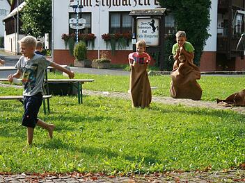 Wasser aus dem vollgelaufenen Boot schöpfen und dann auch noch Sackhüpfen - beim Aktionstag des Wernarzer Obst- und Gartenbauvereins im Gemeinschaftsgarten in Eckarts war einiges geboten. Foto: Gabriele Sell