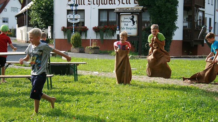Wasser aus dem vollgelaufenen Boot schöpfen und dann auch noch Sackhüpfen - beim Aktionstag des Wernarzer Obst- und Gartenbauvereins im Gemeinschaftsgarten in Eckarts war einiges geboten. Foto: Gabriele Sell