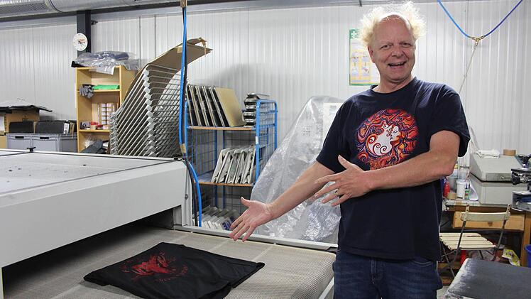 Atze Bauer stellt seinen neuen Trockner vor, mit dem die Farbe auf dem T-Shirt fixiert wird. Foto: Yannick Hupfer