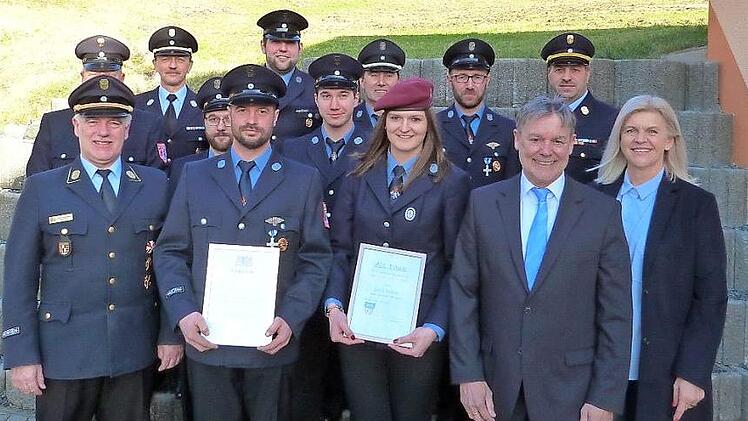 Die Freiwillige Feuerwehr Roßlach freut sich mit ihren Ehrengästen über die Ehrung von Martin Renk (vorne, zweiter von links) mit dem Staatlichen Ehrenzeichen in Silber sowie von Julia Kraus (vorne, dritte von rechts) für ihren aktiven Dienst.  Foto: Heike Schülein