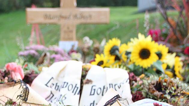 Die Blumen am Grab welken schon. Bei der Beerdigung drückten viele Leute der Familie ihr Beileid aus.  Foto: Ulrike Müller