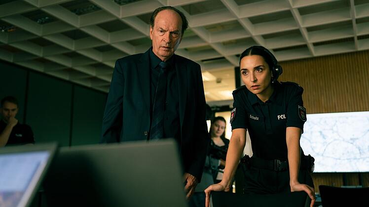 Staatsanwalt Anton Mehringer (Herbert Knaup) verfolgt gemeinsam mit einer jungen Polizeibeamtin (Rona Özkan) über eine Überwachungskamera die Ereignisse im Supermarkt.