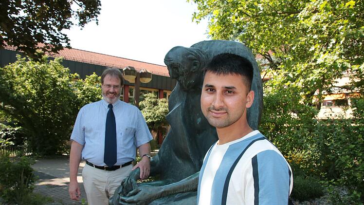 Schulleiter Matthias Ludolph (hinten) freut sich mit Ahmad Towfiq Tokhi über das bestandene Abitur.