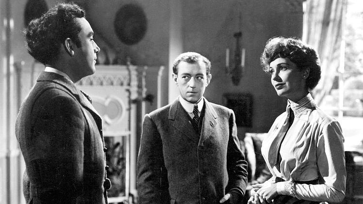 Kurzes Vergn&uuml;gen: Der nichtsahnende Henry (Alec Guinness, Mitte) l&auml;dt Louis Mazzini (Dennis Price, links) zu sich nach Hause ein.