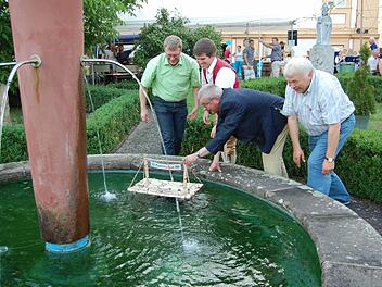Das Floß geht zu Wasser. Bürgermeister Gotthard Schlereth gibt mit einem Schubs noch die Richtung an. V.l. 2.Bürgermeister Jürgen Kolb, Vorsitzender Markus Emmert, Bürgermeister Gotthard Schlereth und von der Musikakademie Helmut Lapp Foto: Günther Straub