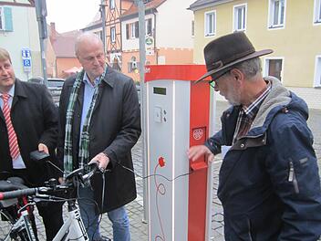 Neben dem Rathaus steht nun eine Ladestation für E-Bikes und E-Autos bereit. Die Bayernwerke, vertreten durch Ralf Schwarz (l.), spendeten der Stadt zudem ein E-Bike. Gerald Brehm und Alois Kunzelmann vom Bauamt (r.) freuen sich über die Klimaschutzmaßnahme.  Foto: Filiz Mailhammer