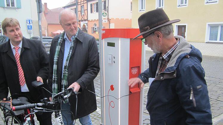 Neben dem Rathaus steht nun eine Ladestation für E-Bikes und E-Autos bereit. Die Bayernwerke, vertreten durch Ralf Schwarz (l.), spendeten der Stadt zudem ein E-Bike. Gerald Brehm und Alois Kunzelmann vom Bauamt (r.) freuen sich über die Klimaschutzmaßnahme.  Foto: Filiz Mailhammer