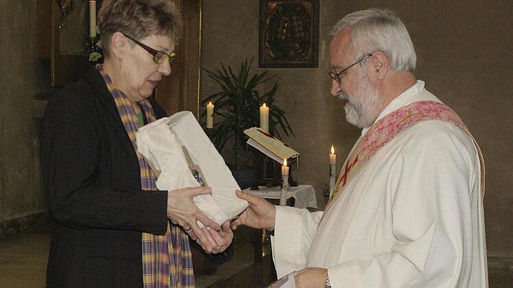Als Abschiedsgeschenk für Diakon Franz Hey (rechts) überbrachte die stellvertretende Vorsitzende der Pfarreiengemeinschaft, Monika Horcher, eine Miniatur des Emblems des "Saalekreuzes".  Foto: Winfried Ehling