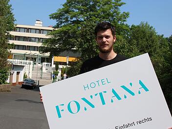 Hotel-Manager Lukas Veth mit dem Hinweis-Schild, bevor es an der Straße angebracht wurde. Foto: Ralf Ruppert