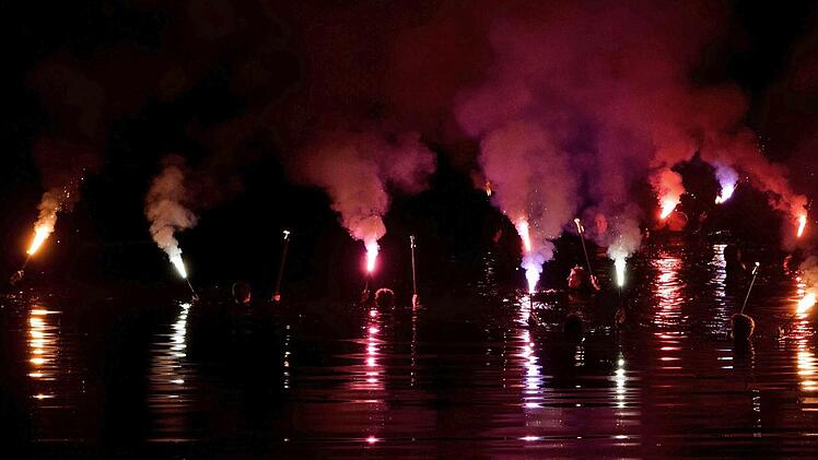 F&uuml;r ein gelungenes Farbenspiel sorgten die Fackelschwimmer im Main. Foto: Dieter Radziej