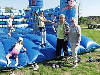 Helen (Mitte) hält ihre Loma Barbara Bauer an der Hand, so macht die Hüpfburg mehr Spaß. Und Erika Ilsemann ist mit den eigenen Enkeln auch dabei. Foto: Pauline Lindner