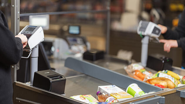 Kunde bezahlt im Supermarkt an einem Kartenlesegerät.