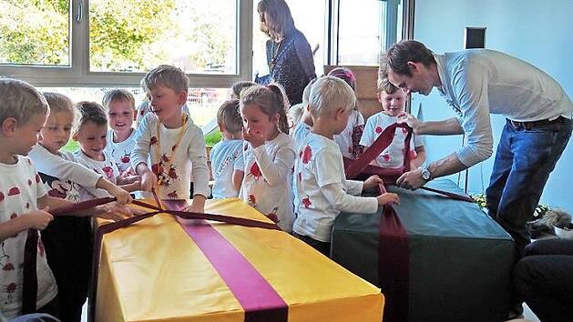 Da strahlen die Kinderaugen: Die Kleinen packen ein gro&szlig;es Geschenk aus, in dem sich - wie sich herausstellen sollte - bequeme Sitzkissen befinden. Foto: Andrea Sp&ouml;rlein