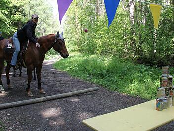 Margit Hempfling beim Dosenwerfen: Wallach "Red Fox" bleibt ruhig, obwohl es scheppert.  Fotos:  Anna Lienhardt