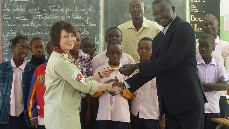 Jutta Geiger übergibt die Spende von 650 Euro für die Schulpatenschaft für Pfadfinder an der katholischen Grundschule Thiès.