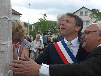 Bürgermeister Siegfried Erhard und sein Amtskollege Thierry Lefort betrachten die Stele, die an das zehnjährige Bestehen der Partnerschaft zwischen Oerlenbach und Douvres-la-Délivrande erinnert. Fotos: Stefan Geiger