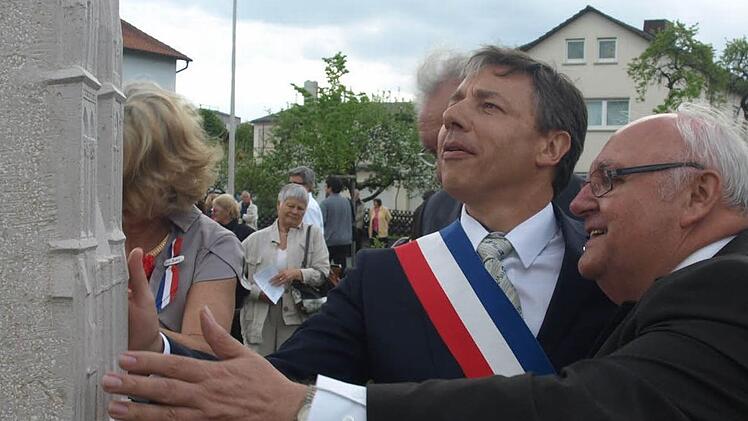 Bürgermeister Siegfried Erhard und sein Amtskollege Thierry Lefort betrachten die Stele, die an das zehnjährige Bestehen der Partnerschaft zwischen Oerlenbach und Douvres-la-Délivrande erinnert. Fotos: Stefan Geiger