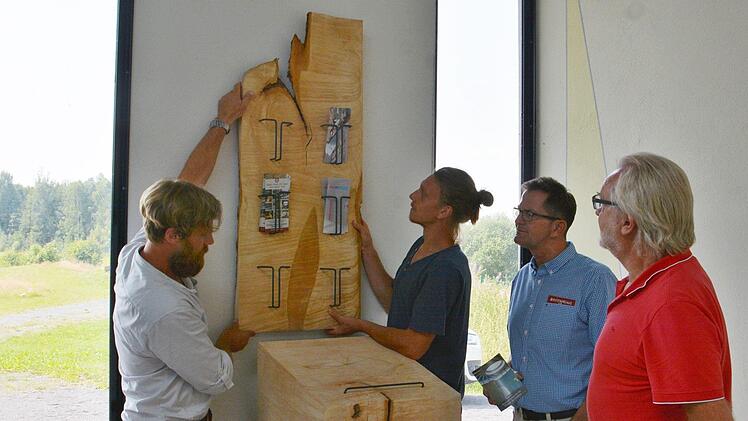 Der neue Schriftenstand in der Autobahnkirche an der A 71 am Parkplatz Thüringer Tor, ist ein Geschenk der Berufsfachschule für Holzbildhauer in Bischofsheim. Es wurde vom Bildhauer Herwig Kemmerich (von links) und seinem Schüler Michael Stenzel aufgestellt. Viel Lob gab es von Rhön-Grabfelds stellvertretenden Landrat Peter Suckfüll und Ralf Luther, Vorsitzender der Autobahnkirche A 71 .   Foto: Hanns Friedrich