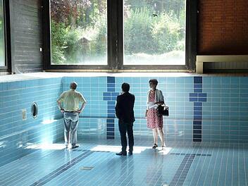 Jürgen W. Heike, Martin Finzel und Susann Biedefeld begutachten das Schwimmbecken im Freizeitzentrum von Witzmannsberg. Foto: Gemeinde Ahorn