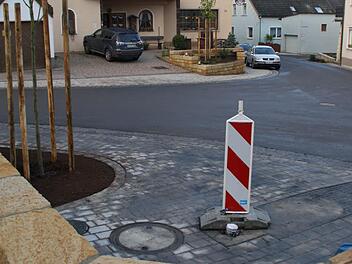 Nur der Brunnen und eine Bank auf dem kleinen Platz im Dorfzentrum (im Vordergrund) fehlen noch, um der Dorferneuerungsmaßnahme "Frankenstraße und Brauereistraße" in Roßstadt das Sahnehäubchen aufzusetzen. Der Straßenbau lief ideal und konnte noch vor der Winterpause komplett abgeschlossen werden. Foto: Sabine Weinbeer