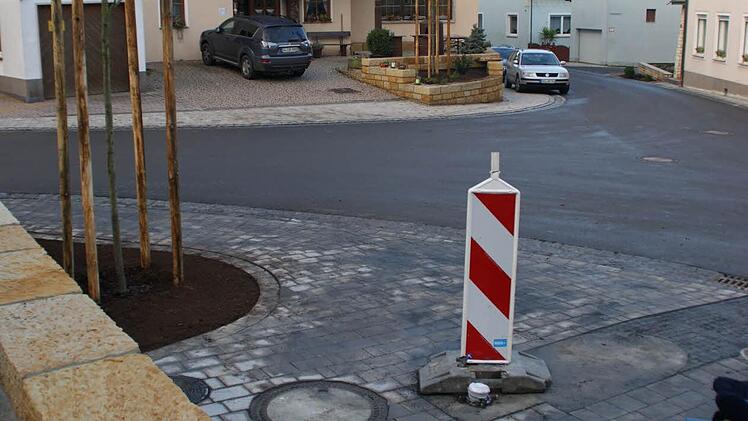 Nur der Brunnen und eine Bank auf dem kleinen Platz im Dorfzentrum (im Vordergrund) fehlen noch, um der Dorferneuerungsmaßnahme "Frankenstraße und Brauereistraße" in Roßstadt das Sahnehäubchen aufzusetzen. Der Straßenbau lief ideal und konnte noch vor der Winterpause komplett abgeschlossen werden. Foto: Sabine Weinbeer