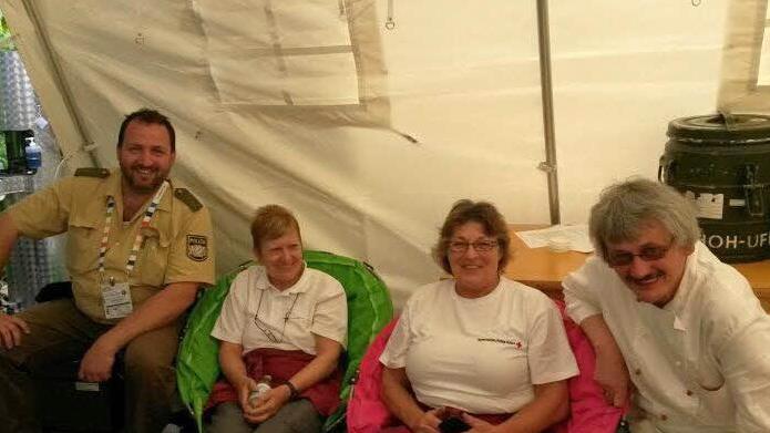 Viel Zeit zum Durchschnaufen blieb den Helfern nicht. Hier gönnen sich Anne Grimmer (Zweite von rechts) und Ortrud Reimann (Zweite von links) eine kurze Verschnaufpause und bekommen vom Koch einer anderen Einheit und einem Polizeibeamten Gesellschaft geleistet.