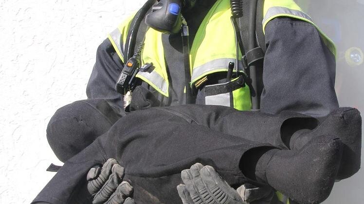 Mit einem Lächeln auf dem Gesicht legt Carola Dietzsch von der Freiwilligen Feuerwehr Marktschorgast ein gerettetes Kind nieder. Die 34jährige ist bereits seit drei Jahren bei der Wehr. Foto: Sonny Adam