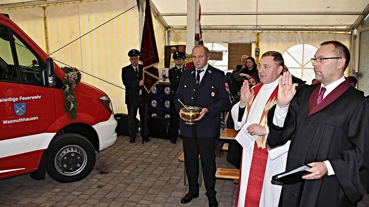 Lektor Volker Sauerteig und der Stadtpfarrer von Seßlach, Norbert Lang (von rechts), segneten das neue Einsatzfahrzeug der Feuerwehr Wasmuthhausen, "Florian 44/1." Foto: Helmut Will