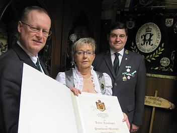 Gauschützenmeister Klaus Jentsch (links) und Oberschützenmeister Jens-Uwe Peter (rechts) überreichten Doris Denninger das von Carin Prinzessin von Sachsen-Coburg und Gotha verliehene Protektoratsabzeichen. Foto: Martin Koch