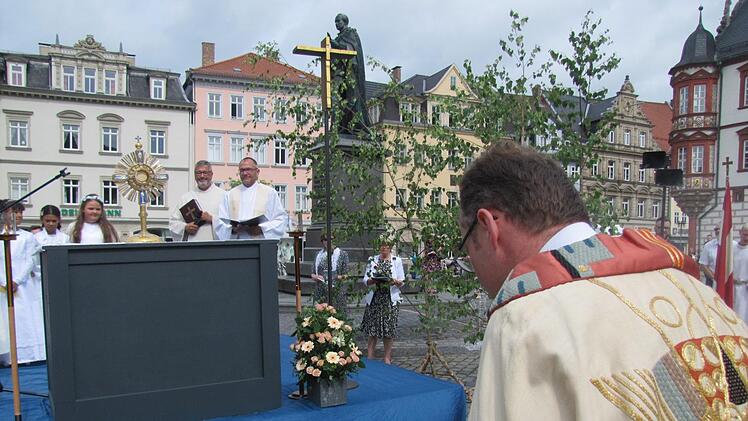 Darum geht es vor allem an Fronleichnam: Der Leib und das Blut Jesu  Christi, gegenwärtig in der Gestalt von Brot und Wein. Auf dem  Hauptaltar im Zentrum des Marktplatzes wird die konsekrierte Hostie in  einem wertvollen Schaugefäß, der Monstranz, präsentiert. Wenig später  erteilt Kaplan Florian Sassik (rechts) damit den Segen an die Gläubigen  und an die Stadt Coburg insgesamt. Am Altar stehen Dekan Roland Huth und  Pastoralreferent Ralph Walta. Foto: Martin Koch