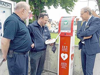 Thomas Heideloff und Andreas Lambert erklären Bürgermeister German Hacker (von links) vor der Polizeiinspektion die Funktionsweise der neuen AED-Säulen.