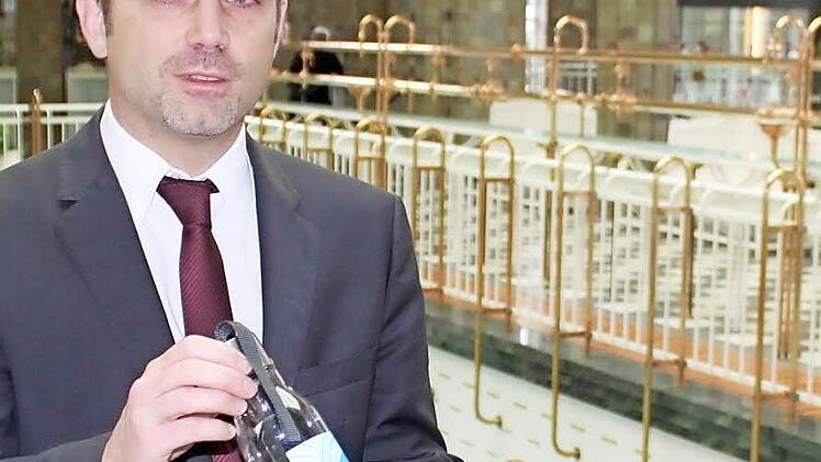 Kurdirektor Oette mit dem Vorausmodell einer Brunnen-Flasche. Foto: Mäuser