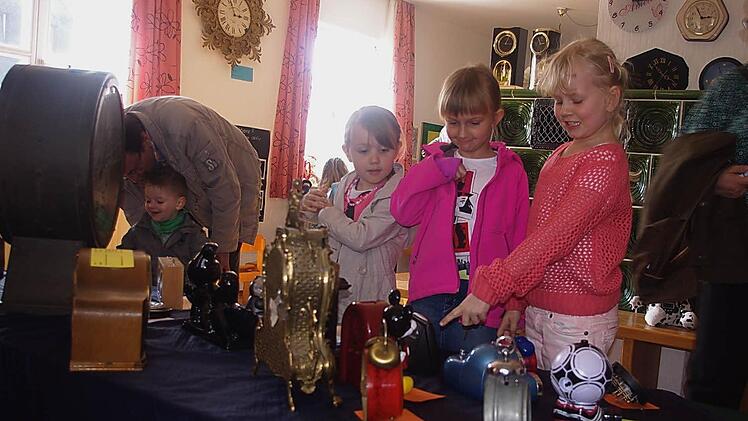 Lea, Nele und Amelie betrachten die Uhren-Ausstellung.