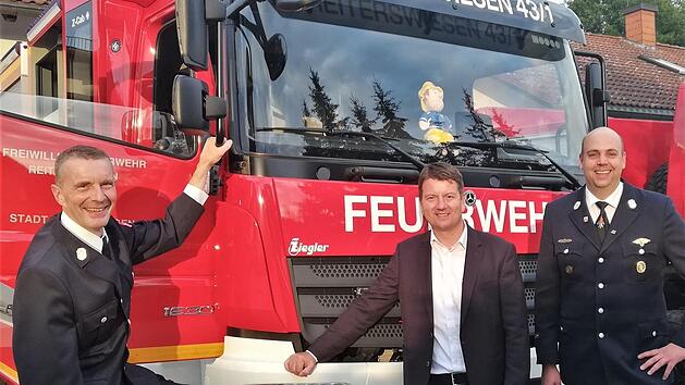 Staatssekretär Sandro Kirchner (CSU, Mitte) mit Bernd Ort (links), dem Kommandanten der Freiwilligen Feuerwehr Reiterswiesen, und dessen Stellvertreter Tobias Dittrich vor dem neuen Löschfahrzeug LF 10