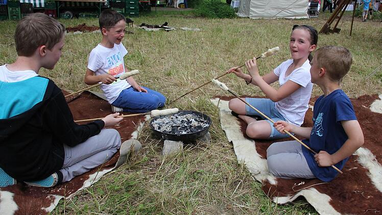 Im Mittelalter-Lager gibt es kostenloses Stockbrot vom Lagerfeuer: Eileen (Zweite von rechts) und ihre Freunde lassen es sich munden.