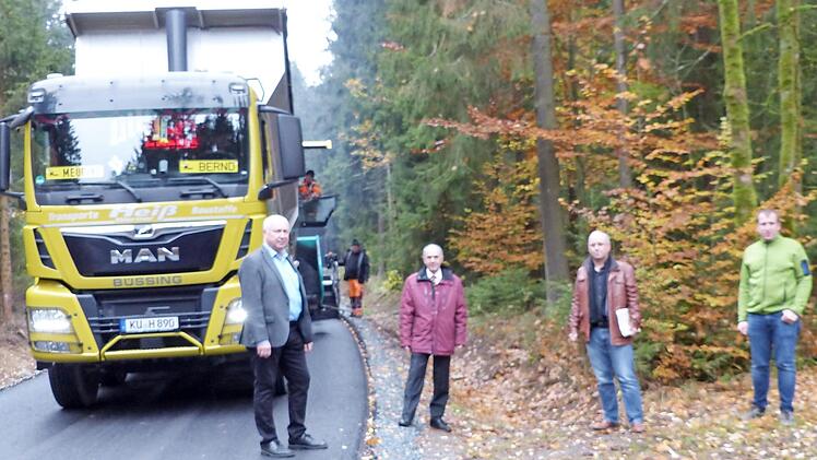 Fertiger der Guttenberger Straßenbaugesellschaft beim Aufbringen der Asphalttragschicht auf der Gemeindeverbindungsstraße nach Hermes; mit im Bild (von links) VG-Geschäftsstellenleiter Michael Laaber, Bürgermeister Franz Uome, Bauamtsleiter Roland Tiroch und GSG-Geschäftsführer Christian Heiß Foto: K.-P. Wulf