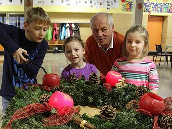 Der Stadtsteinacher Schulleiter Michael Pfitzner will den Schülern den "Duft" der Weihnacht, zu dem auch echte Kerzen gehören, nicht vorenthalten: Tim Beckmann (9) zündet den Adventskranz an, Julia Straubinger (6) und Leni Witzgall (7) stehen andächtig daneben. Fotos: Sonja Adam