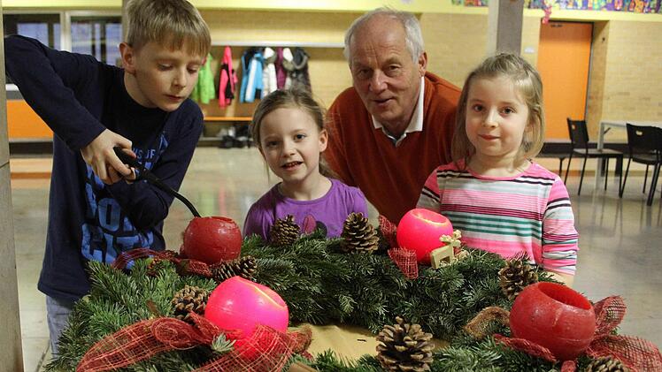 Der Stadtsteinacher Schulleiter Michael Pfitzner will den Schülern den "Duft" der Weihnacht, zu dem auch echte Kerzen gehören, nicht vorenthalten: Tim Beckmann (9) zündet den Adventskranz an, Julia Straubinger (6) und Leni Witzgall (7) stehen andächtig daneben. Fotos: Sonja Adam