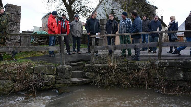 Dorfbewohner und Behördenvertreter schauen sich bei einer Begehung den Klingenbach an. Foto: Elisabeth Assmann