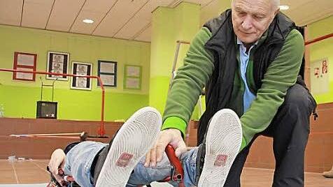 Sportlehrer Wolfgang Klecker (kniend) zeigt, wie man mit den Füßen die Hörner des Rodlers zum Steuern benutzt.